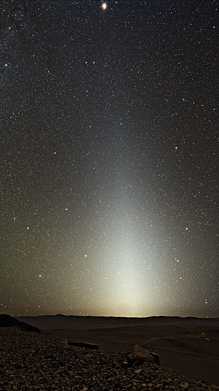 A glorious starry sky, with a bright column due to zodiacal light, illuminates the desert landscape around Cerro Paranal, home to ESO's Very Large Telescope (VLT).